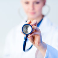 Doctor holding out stethescope with focus on object